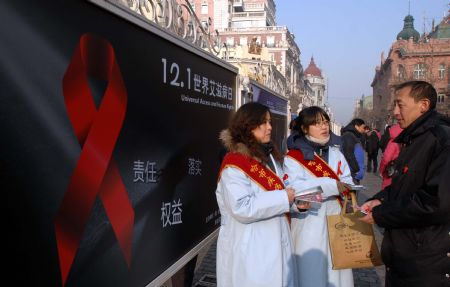 Volunteers distribute pamphlets to passerbys urging for a concerted effort to battle AIDS during an AIDS-awareness event in Harbin, capital of northeast China&apos;s Heilongjiang Province, Dec. 1, 2009, World AIDS Day. (Xinhua/Wang Song)