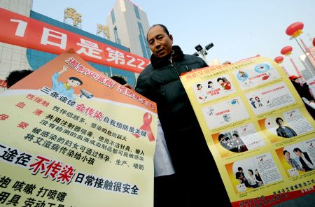  A medical worker holds posters for AIDS prevention during an AIDS-awareness event in Zhengzhou, capital of central China&apos;s Henan Province, Dec. 1, 2009, World AIDS Day. (Xinhua/Zhu Xiang)