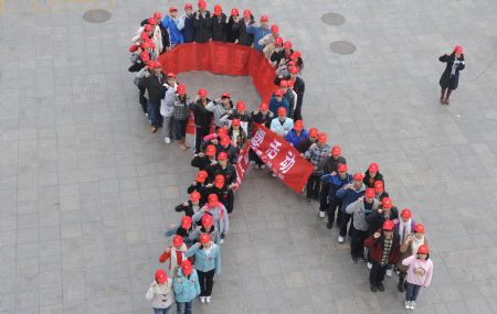 Volunteers stand in the form of a huge AIDS symbol during an AIDS-awareness event inside Sichuan University in Chengdu, capital of southwest China&apos;s Sichuan Province on Dec. 1, 2009, World AIDS Day. (Xinhua/Jiang Hongjing)