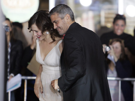 Actor George Clooney escorts co-star Vera Farmiga after she greeted fans at the premiere of their new film "Up In The Air" in Los Angeles, California November 30, 2009.