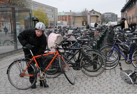 A man locks his bicycle at a free parking lot for bicycles in Copenhagen, capital of Denmark, on Nov. 23, 2009. Copenhagen is known as one of the most bicycle-friendly cities in the world. 36% of all citizens commute to work or school by bicycle. Also, the city&apos;s bicycle paths are extensive and well used. The local government has also taken some measures to promote the energy-efficient, economical and enjoyable means of transportation. (Xinhua/Zhao Changchun)