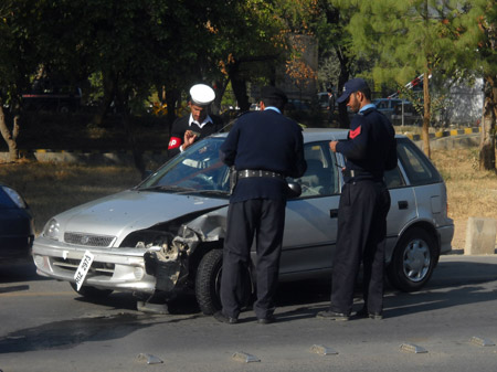 Security forces check a damaged car after a blast at Pakistan&apos;s Navy headquaters in Islamabad, capital of Pakistan, Dec. 2, 2009. The suicide bombing resulted in at least one dead and three others injured. (Xinhua/Bilal Malik)