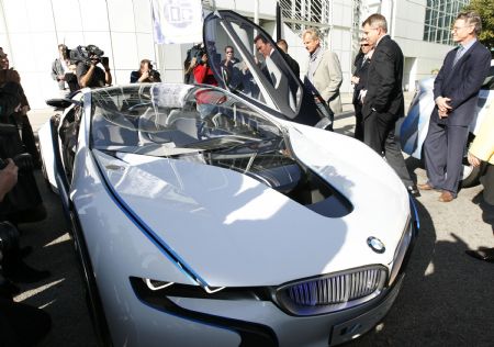 California governor Arnold Schwarzenegger (background, seen through door) tours alternative fuel vehicles during a preview at the 2009 L.A. Auto Show as he inspects the BWM Vision EfficientDynamics Concept car in Los Angeles, California December 1, 2009. 