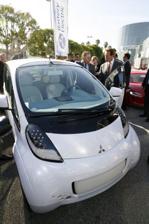 California governor Arnold Schwarzenegger (R) tours alternative fuel vehicles during a preview at the 2009 L.A. Auto Show as he inspects a Mitsubishi iMiev electric car in Los Angeles, California December 1, 2009.