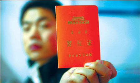 A man shows his temporary residence permit at a police station in Chaoyang district yesterday. Wang Jing
