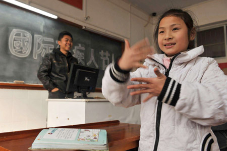 Deaf-mute pupil Cheng Huawen (R) uses dactylology to express her understanding of World Disability Day at class in Guiyang, capital of southwest China&apos;s Guizhou Province, Dec. 3, 2009. Activities were held on Dec. 3 all over China to mark the 18th World Disability Day.