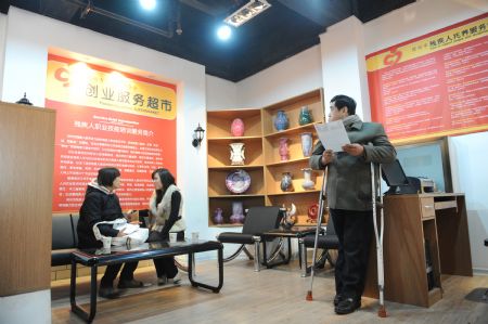 A disabled man (R) visits a disability service supermarket in Zhengzhou, capital of central China&apos;s Henan Province, Dec. 3, 2009. The supermarket founded by local disabled persons&apos; federation to assist disabled persons in getting jobs opened on Thursday. Activities were held on Dec. 3 all over China to mark the 18th World Disability Day.