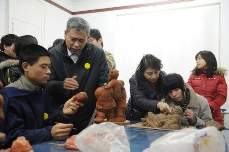 Disabled young people study making clay sculptures under masters&apos; instructions at a disability service supermarket in Zhengzhou, capital of central China&apos;s Henan Province, Dec. 3, 2009. The supermarket founded by local disabled persons&apos; federation to assist disabled persons in getting jobs opened on Thursday. Activities were held on Dec. 3 all over China to mark the 18th World Disability Day.