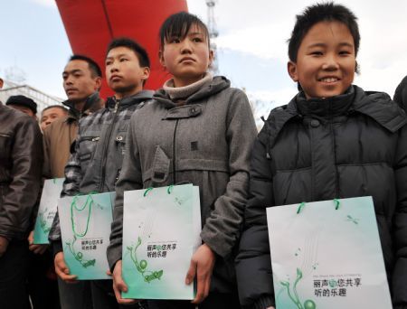 Disabled children hold donated audiphone at a hand-over ceremony in Yinchuan, capital of northwest China&apos;s Ningxia Hui Autonomous Region, Dec. 3, 2009.