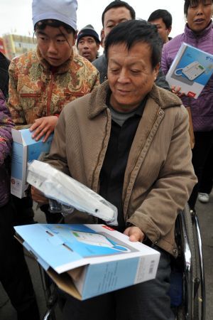 A disabled man unfolds a telephone set at a donations hand-over ceremony in Yinchuan, capital of northwest China&apos;s Ningxia Hui Autonomous Region, Dec. 3, 2009. One thousand telephone set with function of radio and 21 audiphone were donated to over 1,000 disabled people at the ceremony. Activities were held on Dec. 3 all over China to mark the 18th World Disability Day. 