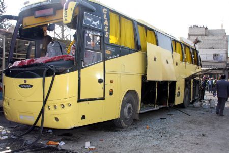 People look at the wreckage of a bus after a blast ripped through it in Sayeda Zainabs, Dec. 3, 2009. Syrian Interior Minister Mohammad Sammour Thursday said the bus blast in Damascus is "not a terrorist attack," pan-Arab al-Jazeera TV reported. In press statements, Sammour said only three people have been killed when the tyre of the bus exploded. The bus was carrying Shiite Iranians who were on a tourist visit to the holy shrine of Sayeda Zainab in southern Damascus.