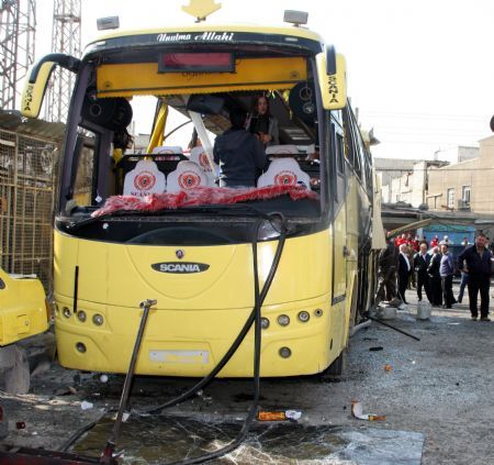 People look at the wreckage of a bus after a blast ripped through it in Sayeda Zainab, Dec. 3, 2009. Syrian Interior Minister Mohammad Sammour Thursday said the bus blast in Damascus is "not a terrorist attack," pan-Arab al-Jazeera TV reported. In press statements, Sammour said only three people have been killed when the tyre of the bus exploded. The bus was carrying Shiite Iranians who were on a tourist visit to the holy shrine of Sayeda Zainab in southern Damascus.