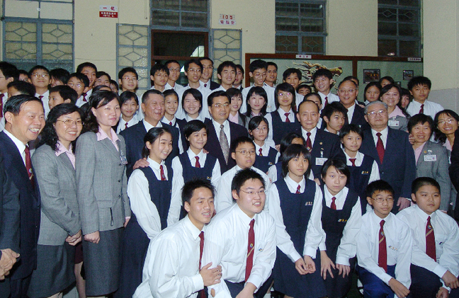 President Hu Jintao poses for a group photo with the students of the Workers Children School. 5. President Hu Jintao poses with a girl living in Macao. The picture was taken on Dec. 19, 2004.