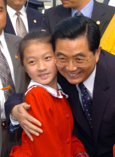 President Hu Jintao poses with a girl living in Macao. The picture was taken on Dec. 19, 2004. 