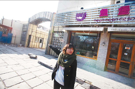 Qin Rong points to her restaurant, one of four buildings standing intact yesterday. Wang Jing