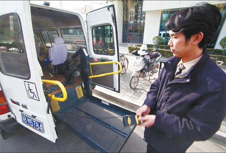 Beijing taxi driver Yang Bo demonstrates how to use his wheelchair-accessible taxi yesterday. 