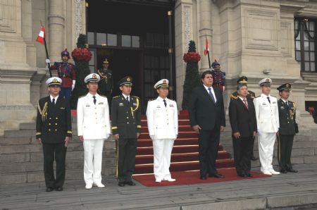 Visiting Major General Wang Fushan (4th L, Front), vice-commander of the North Sea Fleet of the Chinese People&apos;s Liberation Army Navy, and Peruvian President Alan Garcia (4th R, Front) attend a welcoming ceremony in Lima, capital of Peru, on Dec. 5, 2009.[Xinhua]