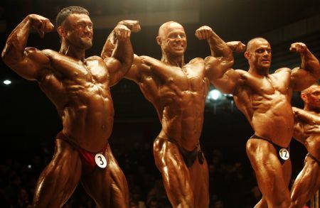 Competitors perform during the Ukrainian bodybuilder competition in Kiev December 5, 2009.[Xinhua/Reuters]