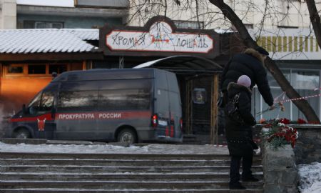 People lay flowers in front of the Lame Horse nightclub in the Ural city of Perm, Russia, Dec. 5, 2009. At least 109 people were killed and dozens injured overnight to Saturday when a blaze sparked by indoor fireworks swept through the nightclub, one of the deadliest tragedies to hit Russia in recent years. [Xinhua]