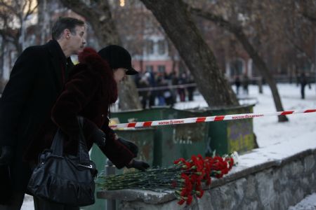 People lay flowers in front of the Lame Horse nightclub in the Ural city of Perm, Russia, Dec. 5, 2009. [Xinhua]