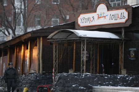 A policeman stands guard in front of the Lame Horse nightclub in the Ural city of Perm, Russia, Dec. 5, 2009. [Xinhua]