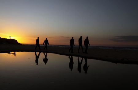 Palestinian men walk on the seashore at sunset in Gaza City, Dec.5, 2009.[Xinhua/Wissam Nassar]