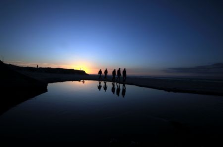 Palestinian men walk on the seashore at sunset in Gaza City, Dec.5, 2009.[Xinhua/Wissam Nassar]