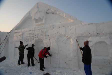 Local snow artists work on snow-carving at a snow park in Mudanjiang, northeast China&apos;s Heilongjiang Province, Dec. 6, 2009. [Chen Zhanhui/Xinhua]