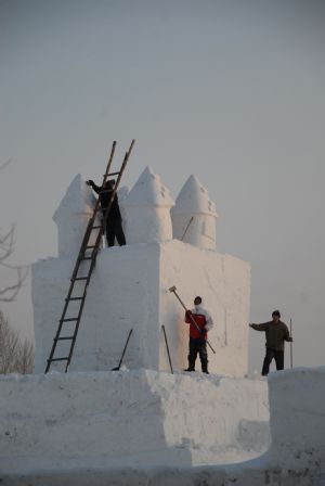 Local snow artists work on snow-carving at a snow park in Mudanjiang, northeast China&apos;s Heilongjiang Province, Dec. 6, 2009. [Chen Zhanhui/Xinhua]