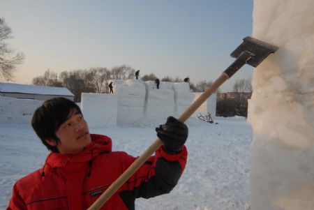 A local snow artist works on a snow-carving at a snow park in Mudanjiang, northeast China&apos;s Heilongjiang province, Dec. 6, 2009. [Chen Zhanhui/Xinhua]