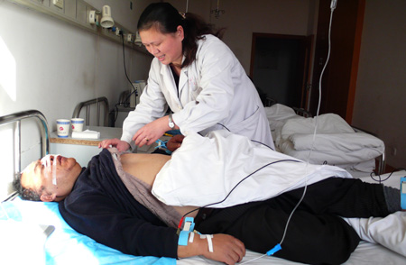 A doctor is treating a man who was injured in the explosion at a hospital in Hubei on December 5, 2009. [Xinhua] 