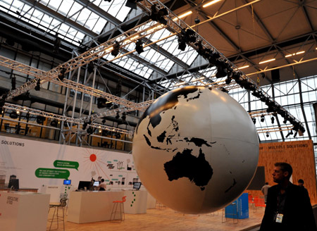 A man walks past a earth ball prior to the 15th United Nations Climate Change Conference (COP15) at Bella Center in Copenhagen, capital of Demark, Dec. 6, 2009. The conference will be held from Dec. 7 to 18. [Xu Suhui/Xinhua]