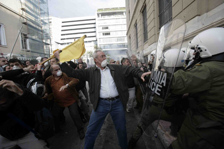 Greek protestors clash with riot police in Athens on Dec. 6, 2009, during a massive demonstration commemorating the fatal shooting of 15-year-old Alexandros Grigoropoulos one year ago. [Marios Lolos/Xinhua]