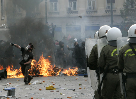 Greek protestors clash with riot police in Athens on Dec. 6, 2009, during a massive demonstration commemorating the fatal shooting of 15-year-old Alexandros Grigoropoulos one year ago. [Marios Lolos/Xinhua]