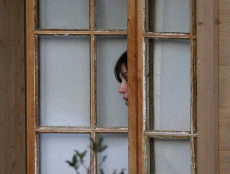 French actress Emmanuelle Seigner, wife of Oscar-winning film director Roman Polanski looks out of a window of chalet &apos;Milky Way&apos; in the Swiss mountain resort of Gstaad December 6, 2009. [Xinhua/Reuters]