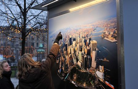 People look at a picture on display during a photo exhibition on climate change in Danish capital Copenhagen on Dec. 6, 2009. The United Nations Climate Change Conference 2009 will open in Copenhagen on Monday. [Xu Suhui/Xinhua] 