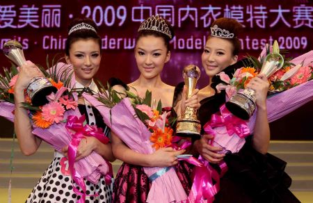 The first prize winner Mao Huan(C) is flanked by runner-up Wang Mingshun and third prize winner Xu Tingting as they pose for a photo after the final of China Underwear Contest 2009 in Nanning, capital of southwest China&apos;s Guangxi Zhuang Autonomous Region, on Dec. 6, 2009. [Chen Jianli/Xinhua]