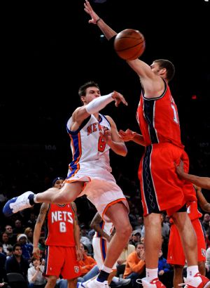 Danilo Gallinari (L) of New York Knicks passes the ball during the NBA basketball game against New Jersey Nets in New York, the United States, December 6, 2009. Knicks won the match 106-97.[Xinhua]