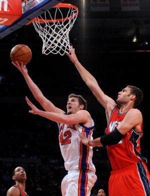 David Lee (L) of New York Knicks drives to the basket during the NBA basketball game against New Jersey Nets in New York, the United States, December 6, 2009. Knicks won the match 106-97.[Xinhua] 