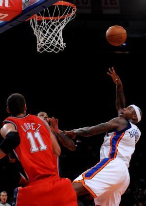 Al Harrington (R) of New York Knicks shoots a basket during the NBA basketball game against New Jersey Nets in New York, the United States, December 6, 2009. Knicks won the match 106-97.[Xinhua]