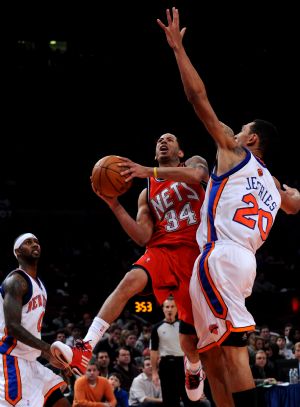 Devin Harris (C) of New Jersey Nets drives to the basket during the NBA basketball game against New York Knicks in New York, the United States, December 6, 2009. Knicks won the match 106-97.[Xinhua]