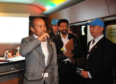 Chairman of China's Vanke Group Wang Shi, a representative of Chinese enterprisers, speaks on the 'Climate Express' after its departure from Brussels, capital of Belgium, Dec. 5, 2009.[Xinhua]