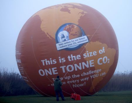 An environmental activist anchors a large balloon to the ground outside the congress centre, before the opening of the United Nations in Copenhagen December 7, 2009.[Xinhua/Reuters]
