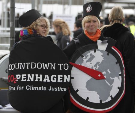 Environmental activists dressed as stopwatches, stand outside the congress centre, before the opening of the United Nations Climate Change Conference 2009 in Copenhagen December 7, 2009.[Xinhua/Reuters]