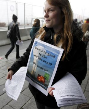 An environmental activist hands out leaftlets outside the congress centre, before the opening of the United Nations Climate Change Conference 2009 in Copenhagen December 7, 2009.[Xinhua/Reuters]