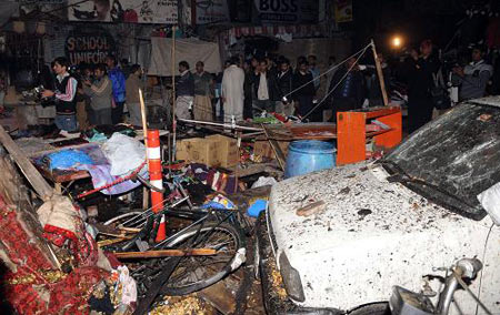 People gather at the scene of explosions in Lahore, Pakistan, Dec. 7, 2009. [Xinhua/AFP]