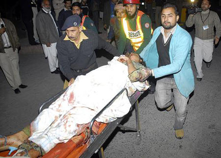 People rush an injured person to a local hospital in Lahore, Pakistan on Monday, Dec. 7, 2009. [Xinhua/AP]