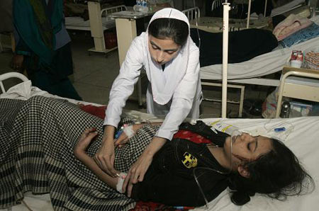 A Pakistani nurse tends to an injured girl at a local hospital in Lahore, Pakistan, Monday, Dec. 7, 2009. [Xinhua/AP]