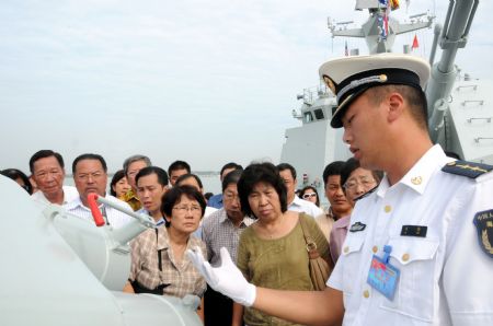 Chinese naval officer Liu Tao introduces to visitors equipment onboard Chinese missile frigate &apos;Xuzhou&apos; at a port in the state of Selangor of Malaysia Dec. 7, 2009.[Li Xueqing/Xinhua]