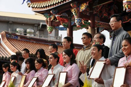 Parents and youth pose for group photo after completing the adult ceremony held in the Confucius Temple of Taipei, southeast China&apos;s Taiwan, Dec. 6, 2009. A total of 130 students took part in the Chinese traditional adult ceremony in Taipei on Sunday. [Wu Ching/Xinhua]